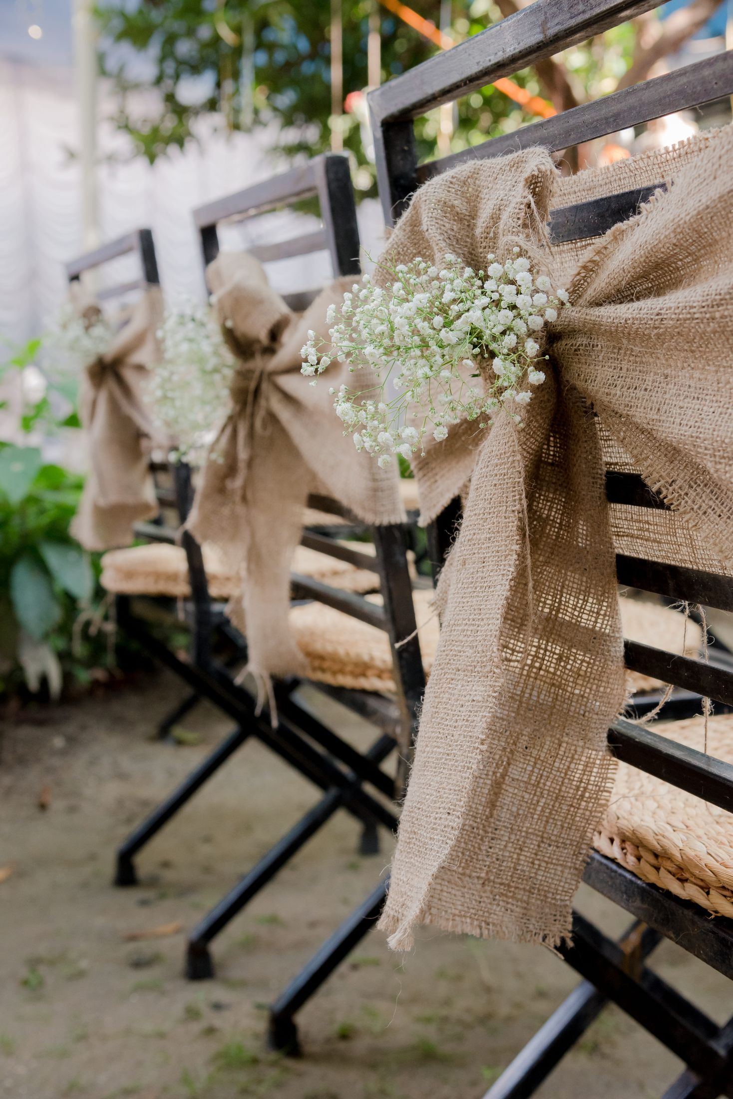 Wedding chair decorated with burlap ribbon and baby's breath flowers