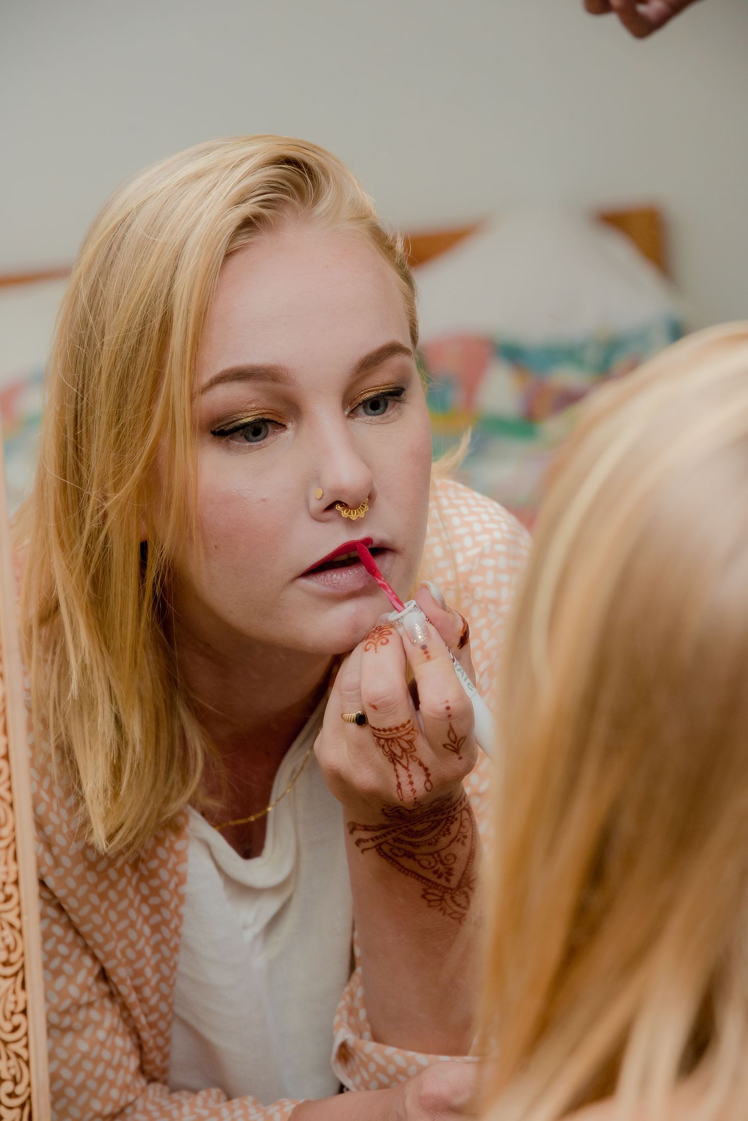 Jana having her lip makeup applied while getting ready for the ceremony