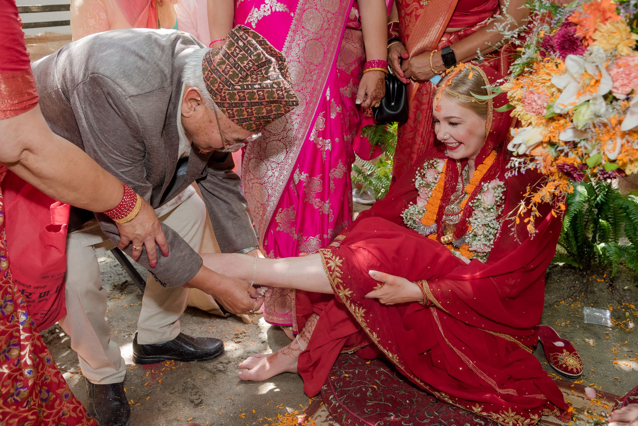 Family draping a white cloth over Raymon during a traditional wedding ritual