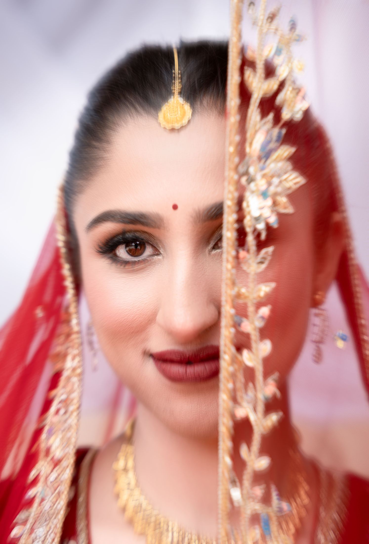 Close-up beauty portrait of Disuja with a red bindi and gold jewelry