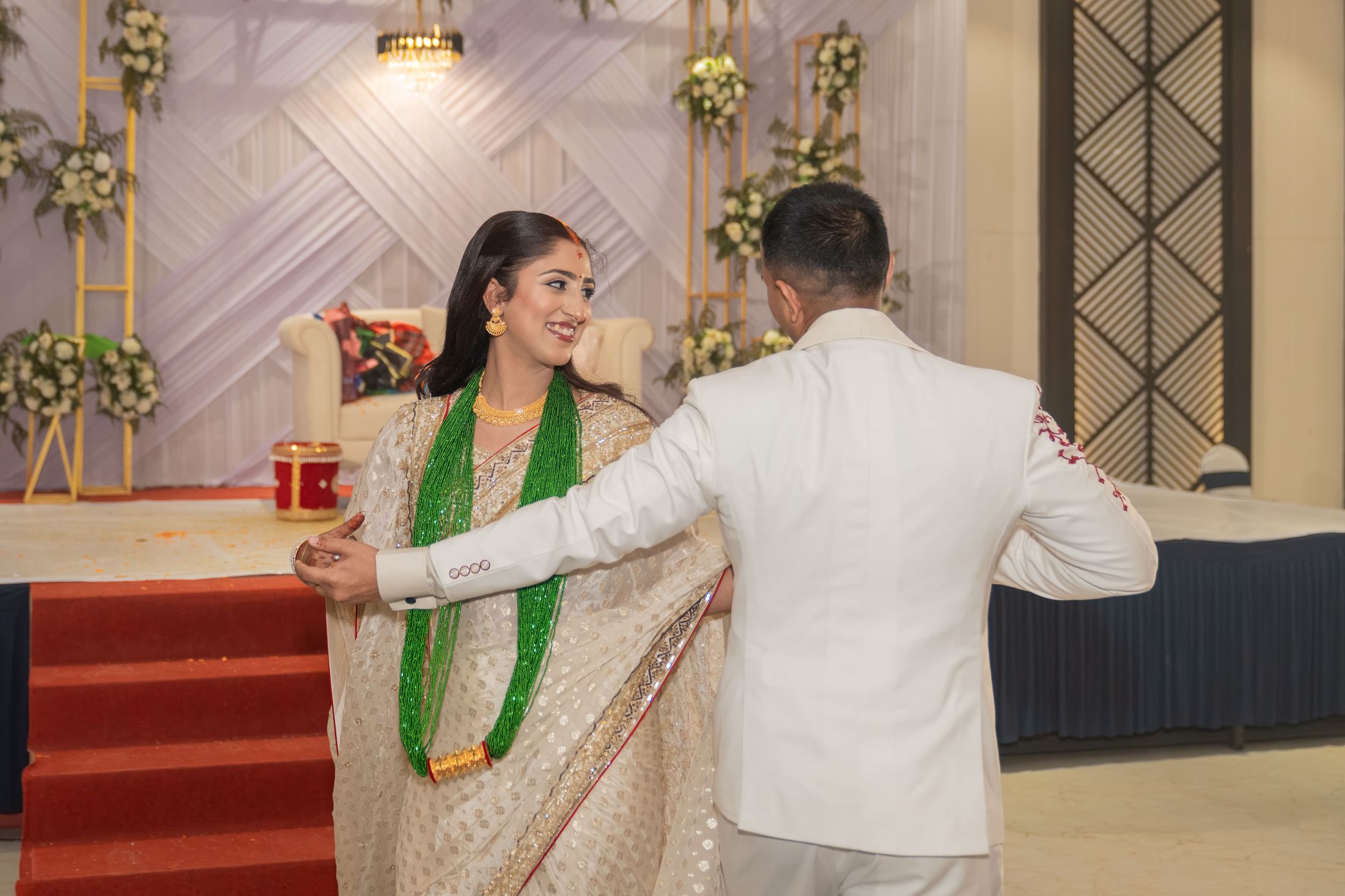 Reception moment with Disuja and Krishna walking arm in arm past the stage, she wearing a green garland