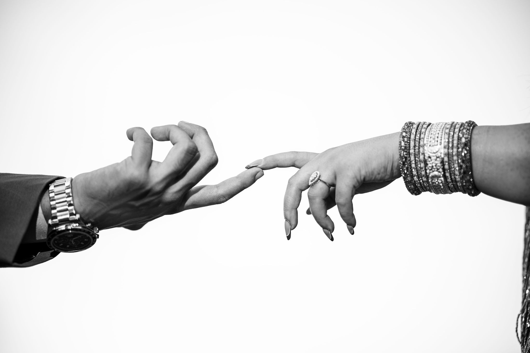 Black and white close-up of Inusha and Prashid's hands reaching toward each other
