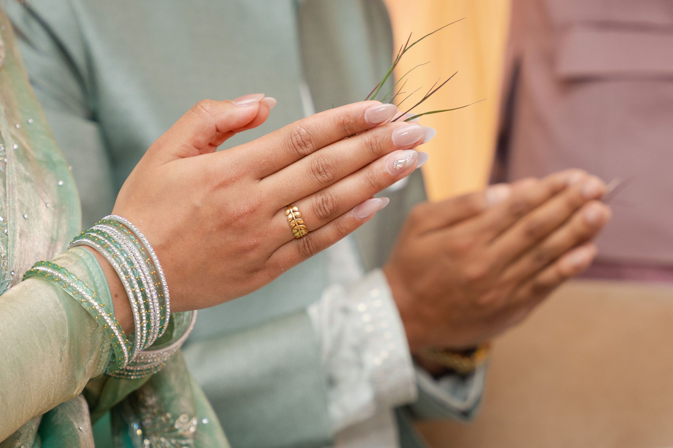 Close-up of Suprabha and Nischal's joined hands with bangles and rings during the ritual, seen from a different angle